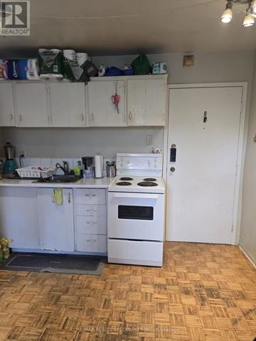 Toronto (Dufferin Grove) multi-family for rent - A kitchen with a white stove and cabinets.