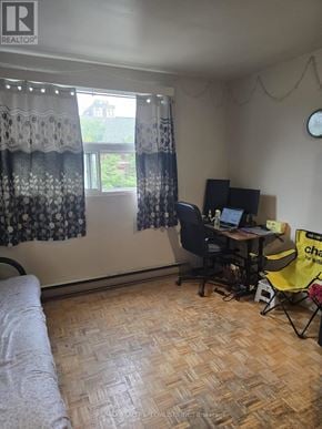 Toronto (Dufferin Grove) multi-family for rent - A room with a desk and a computer, a window with curtains, and a yellow chair.