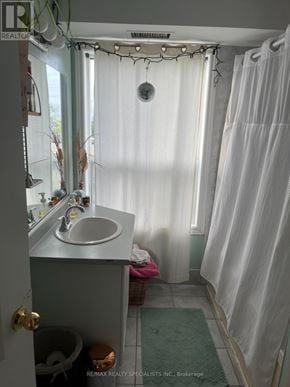 Toronto (Palmerston-Little Italy) multi-family for rent - A room with a window and a kitchen area with a refrigerator.