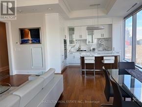 Toronto (Annex) condo for rent - A modern kitchen with white cabinets and a wooden floor.