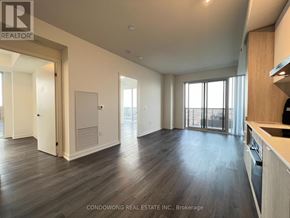 Toronto (Waterfront Communities) condo for rent - A spacious living room with wood flooring and a kitchen area with white appliances.