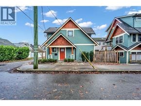 Bc apartment for rent - A house with a red door is in the foreground of a street with other houses in the background.