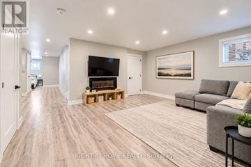 Georgina (Keswick South) apartment for rent - A spacious living room with a grey couch and a wooden floor.
