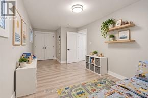 Georgina (Keswick South) apartment for rent - A well-lit, spacious room with a bed, a cabinet, and a shelf with plants and picture frames.
