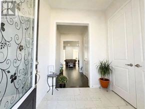 Georgina (Sutton & Jackson's Point) apartment for rent - A hallway with a glass door, a plant on a table, and a white door at the end of the hallway.