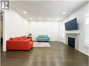 Georgina (Sutton & Jackson's Point) apartment for rent - A living room with a red couch and a green armchair.