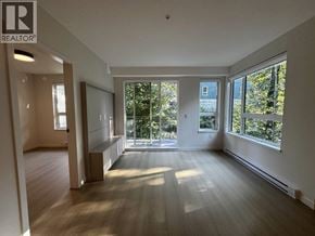 Port Moody apartment for rent - A spacious room with wooden floors and large windows.