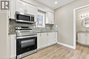 Kitchener apartment for rent - A modern kitchen with white cabinets and stainless steel appliances.