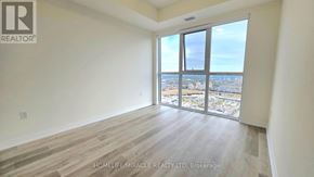 Mississauga (Hurontario) condo for rent - A room with a view of the city through large windows.