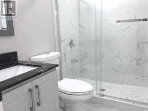 Milton (Walker) apartment for rent - A white toilet sits in a bathroom with a marble shower.