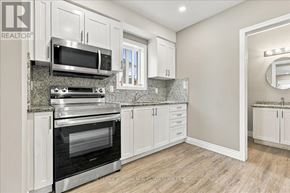 Kitchener apartment for rent - A kitchen with white cabinets and a granite countertop.