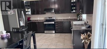 Hamilton (Hannon) apartment for rent - A kitchen with brown cabinets and a black counter top.
