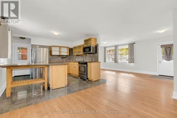 King (Schomberg) apartment for rent - A spacious kitchen with wooden cabinets and a central island.