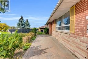 King (Schomberg) apartment for rent - A brick house with a yellow window and a pathway leading to the front door.