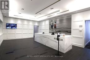 Toronto (Mimico) condo for rent - A realtor's office with a white reception desk and a large screen on the wall.