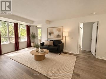 Toronto (West Humber-Clairville) condo for rent - A living room with a black couch, a coffee table, and a painting on the wall.
