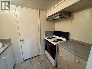 Cambridge apartment for rent - A small kitchen with a stove and a door.