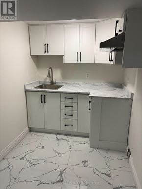 Barrie (Grove East) apartment for rent - A kitchen with marble flooring and white cabinets.