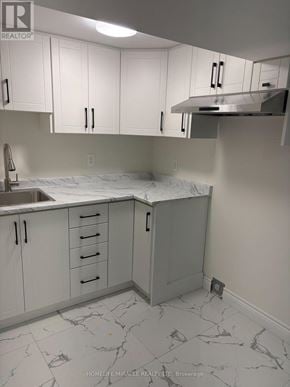 Barrie (Grove East) apartment for rent - A kitchen with white cabinets and marble countertops.