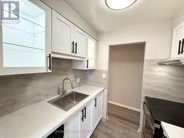St. Catharines (Carlton/Bunting) condo for rent - A kitchen with white cabinets and a sink.