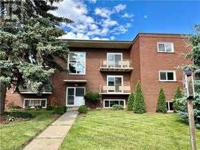 St. Catharines (Carlton/Bunting) condo for rent - A red brick building with a white door and windows.
