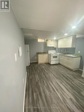 Brampton (Heart Lake East) apartment for rent - A real estate listing photo of a kitchen and living room with wood flooring.