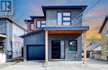 Kitchener duplex for rent - A modern house with a brick facade and a garage door is for sale.