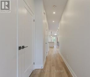 Kitchener duplex for rent - A long hallway with white walls and wood floors.