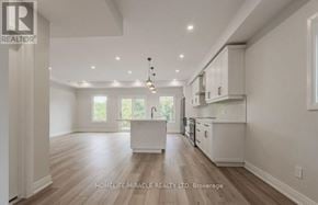 Kitchener duplex for rent - A spacious kitchen with white cabinets and a central island.