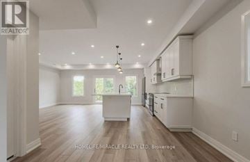 Kitchener duplex for rent - A spacious kitchen with white cabinets and a central island.