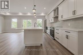 Kitchener duplex for rent - A modern kitchen with white cabinets and a wooden floor.