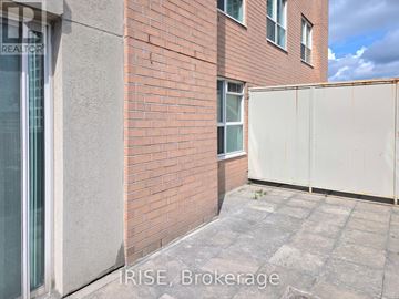 Toronto (Moss Park) condo for rent - A red brick building with a white fence in front.