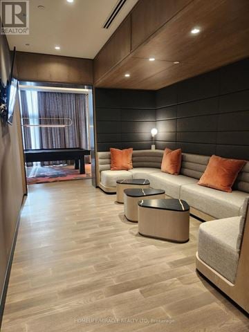 Toronto (Islington-City Centre West) condo for rent - A modern living room with a grey sofa and orange pillows.