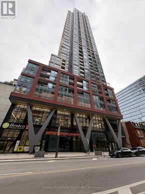 Toronto (Waterfront Communities) condo for rent - A tall building with a Bestic sign on the ground floor.
