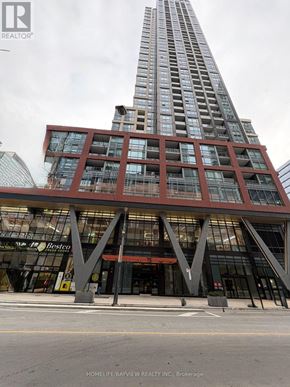 Toronto (Waterfront Communities) condo for rent - A tall building with a glass facade stands in front of a Best Western hotel.
