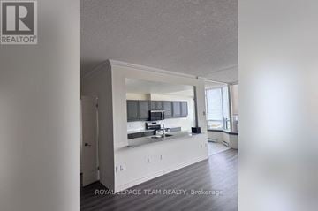 Ottawa condo for rent - A well-lit, spacious kitchen with white cabinets and a large island.
