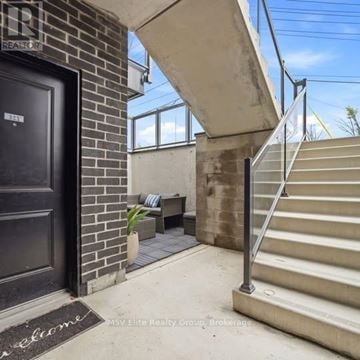 Niagara Falls (Arad/Fallsview) townhouse for rent - A black door with a welcome mat in front of a brick wall.