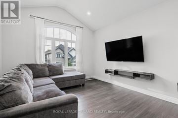 London North (North R) house for rent - A modern living room with a grey sofa and a flat screen TV mounted on the wall.