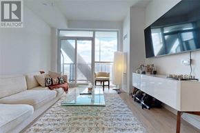 Toronto (Niagara) condo for rent - A living room with a white couch and a glass coffee table.