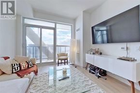 Toronto (Niagara) condo for rent - A living room with a glass table and a flat screen TV mounted on the wall.