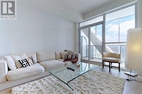Toronto (Niagara) condo for rent - A living room with a white couch and a glass coffee table.
