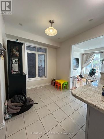 Oakville (Go Glenorchy) townhouse for rent - A kitchen area with a black cabinet, a white counter, and a window with curtains.