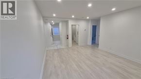 Brantford apartment for rent - A room with a white wall and wooden flooring.