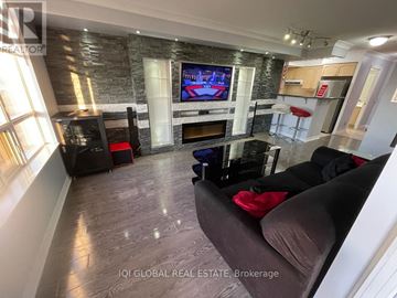 Toronto (West Humber-Clairville) condo for rent - A living room with a grey couch and a television on the wall.
