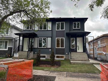 Edmonton apartment for rent - A grey house with a black roof and a white door.