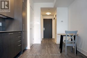 Toronto (Church-Yonge Corridor) condo for rent - A hallway with a chair and a table in the foreground and a door in the background.
