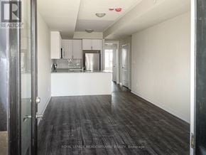 Milton (Cb Cobban) townhouse for rent - A kitchen with white walls and a wooden floor.