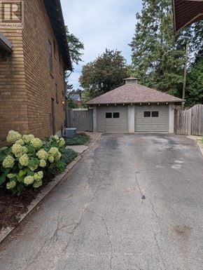 London East (East B) apartment for rent - A driveway leads to a garage with a brick house on the left.