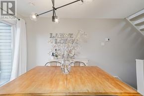 Collingwood townhouse for rent - A dining room with a wooden table and a chandelier.