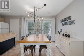 Collingwood townhouse for rent - A dining room with a wooden table and chairs, a chandelier, and a sign that says "Lance Lodge.".